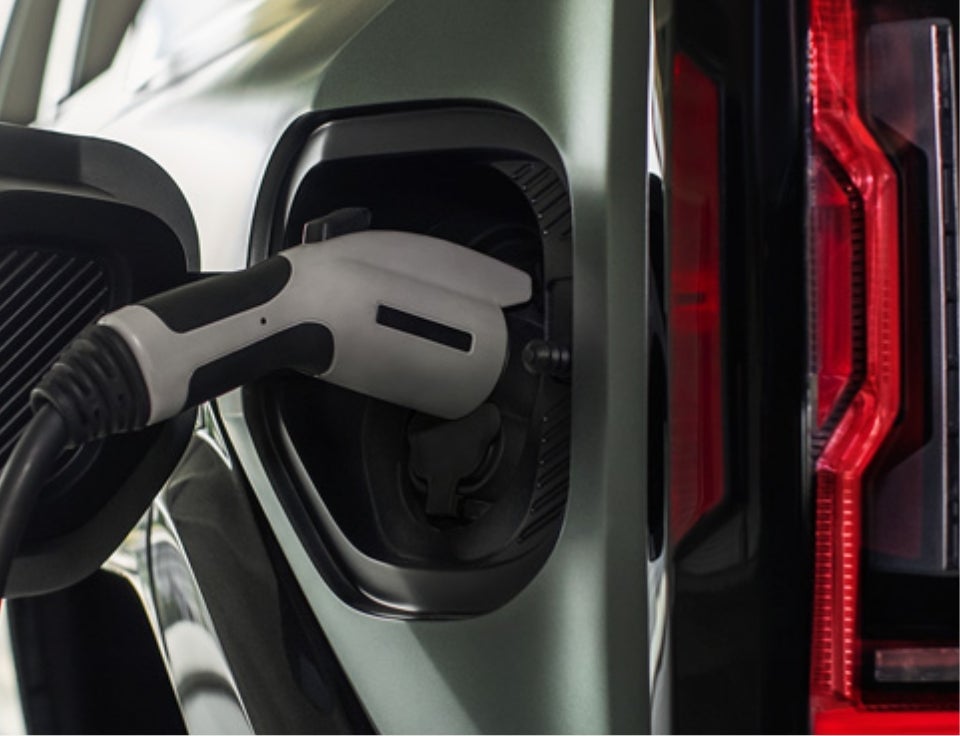 Close up of charging port with charger plugged in on a GMC Hummer EV SUV - Stokes Trainor GMC in Newberry SC